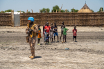 YK:n rauhanturvaaja ja sudanilaisia lapsia taustalla.